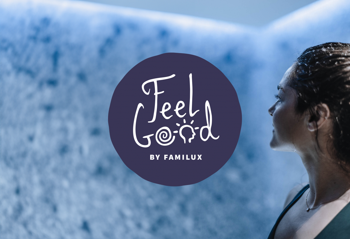 Nahaufnahme einer Frau, die auf eine blaue Wand schaut, in der Mitte das dunkelblaue, runde Logo mit der Aufschrift 