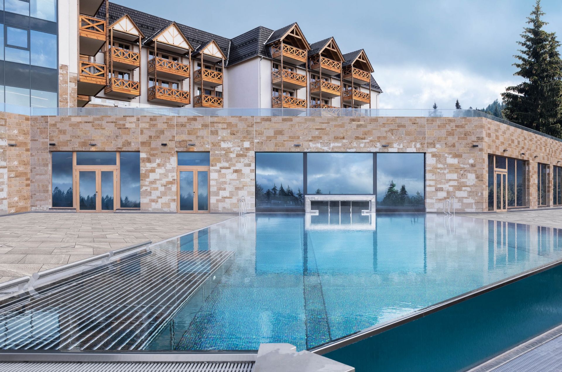 Blick auf das Außenbecken sowie einen Teil des Gebäudes vom Hotel